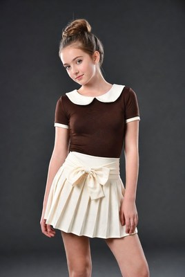 Girl in brown top white skirt