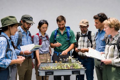 Group examining plants on table
