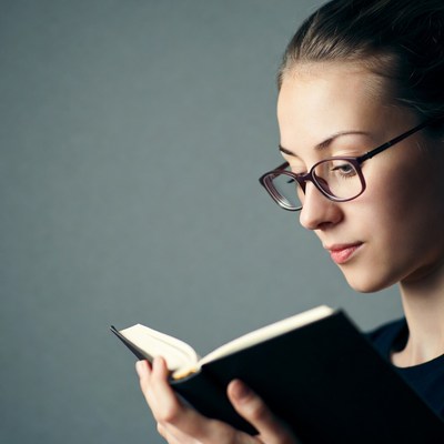 Woman reading book with glasses