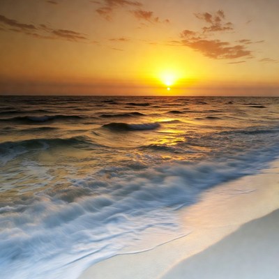 Sunset over ocean waves on beach