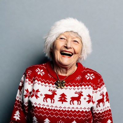 Elderly woman laughing in Christmas sweater