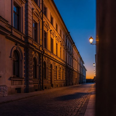 Lit Cobblestone Street Historic Buildings Twilight