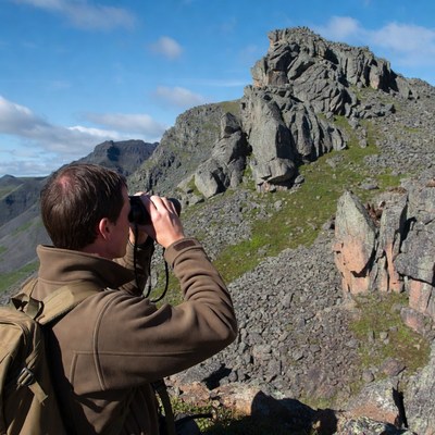 Man using binoculars viewing mountain