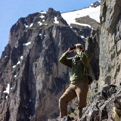 Man using binoculars on snowy mountain