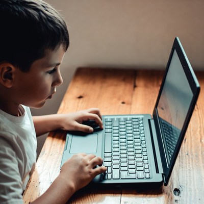Boy using laptop at table