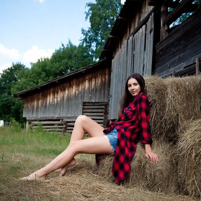 Woman in plaid shirt on hay bale