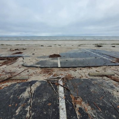 Storm-damaged asphalt on beach