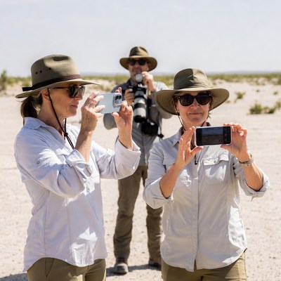 Tourists photographing in desert with guide