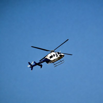 White and blue helicopter flying