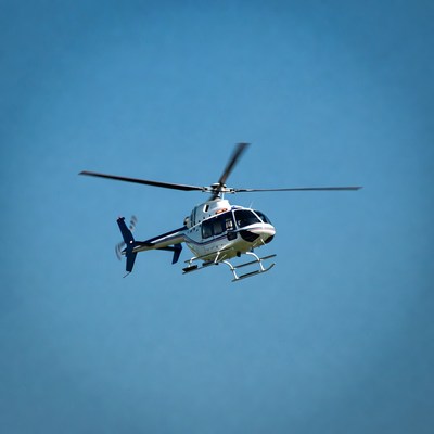 White helicopter flying in blue sky