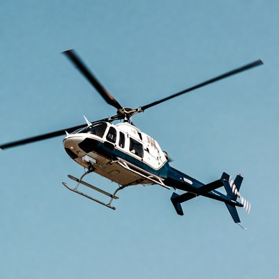 White and blue helicopter flying