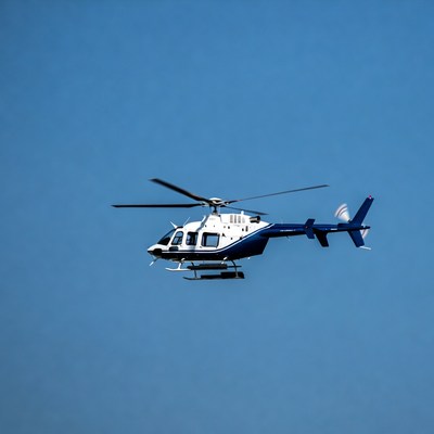 White and blue helicopter flying