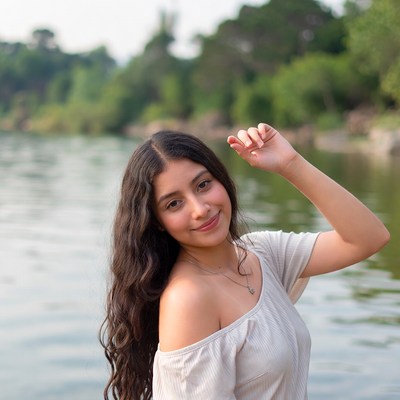 Smiling woman waving by river