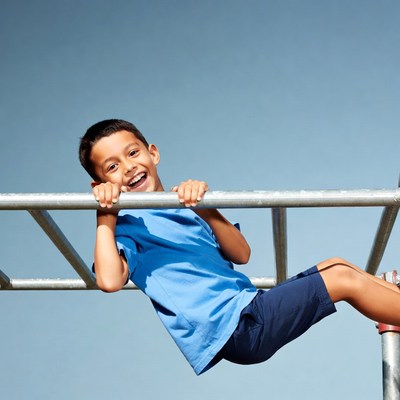 Boy smiling on playground monkey bars