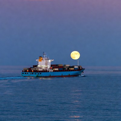 Cargo Ship Sailing with Full Moon