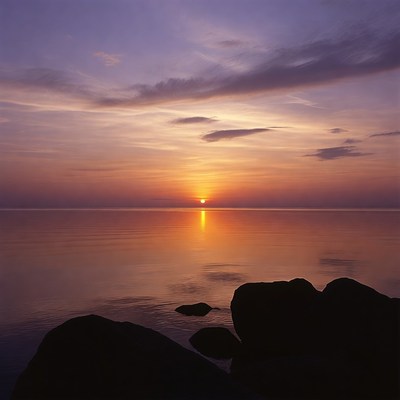 Sunset over calm lake with rocks