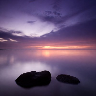 Rocks in Calm Purple Sunset Water