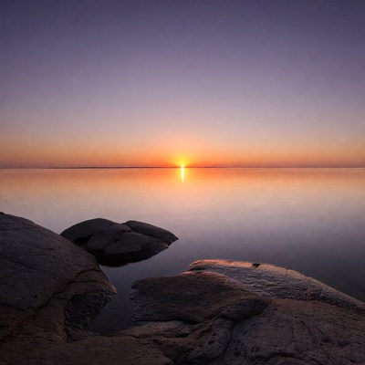 Sunset over calm lake with rocks