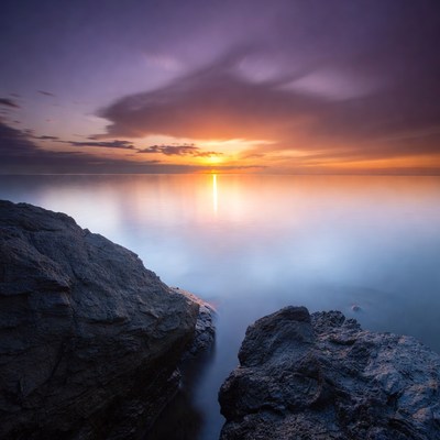 Sunset over ocean with rocks