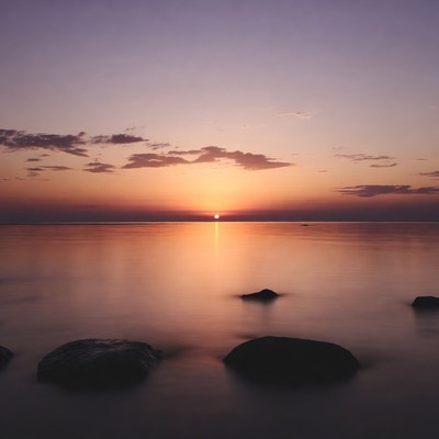 Sunset over calm sea with rocks