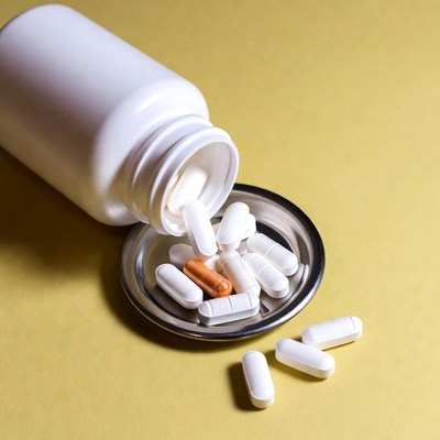 White pill bottle spilling pills