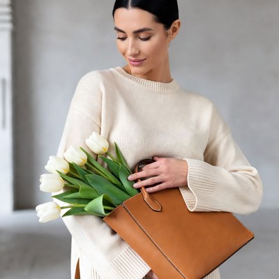 Woman holding tulips and leather bag