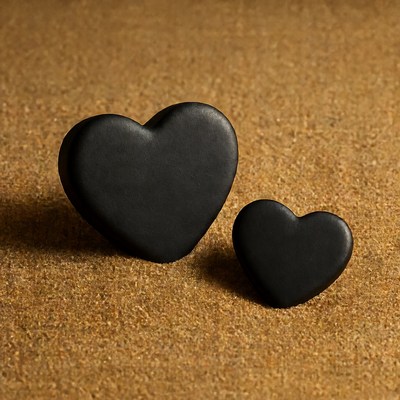 Two Black Hearts on Brown Surface