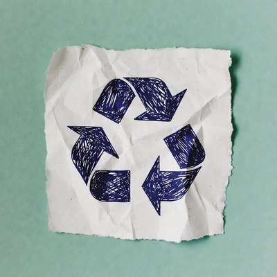 Hand-drawn recycle symbol on crumpled paper