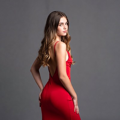Woman in red backless dress profile view