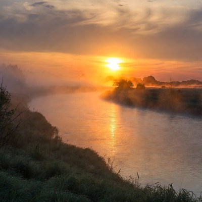 Sunrise over misty river