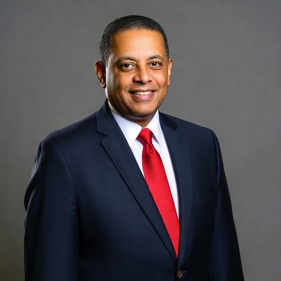 Smiling man in navy suit red tie