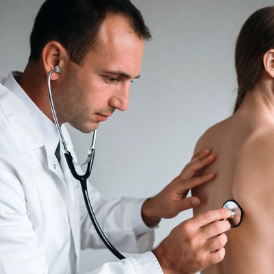 Doctor listening to woman's back