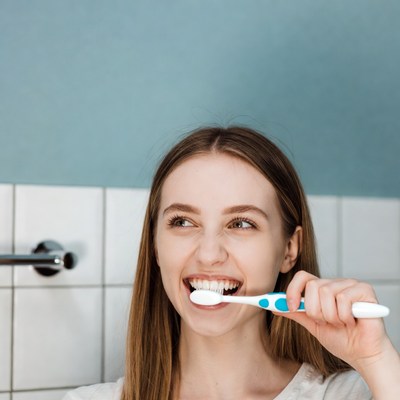 Woman brushing teeth in bathroom