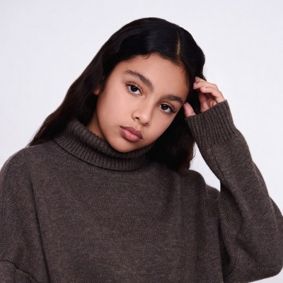 Teen girl in turtleneck touching hair