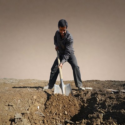 Man digging soil with shovel