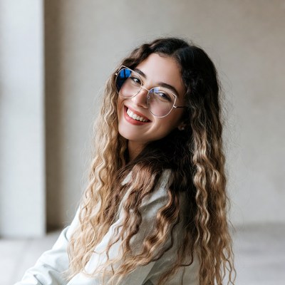 Smiling woman with curly hair and glasses