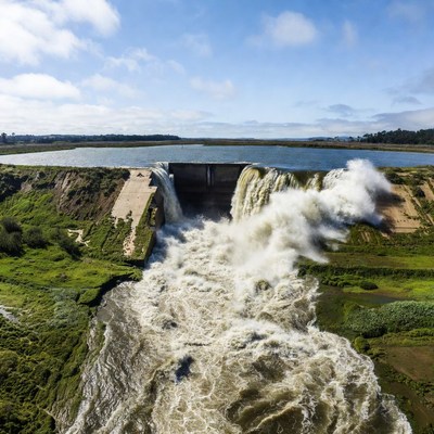 Massive dam spilling water aerial view