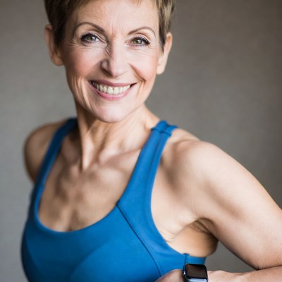 Smiling woman in blue tank top with smartwatch