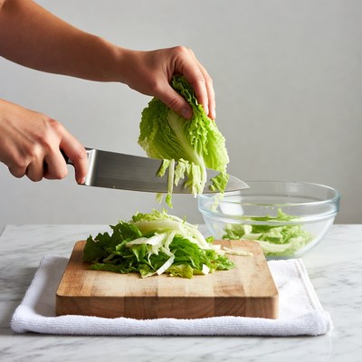 Woman chopping lettuce on cutting board