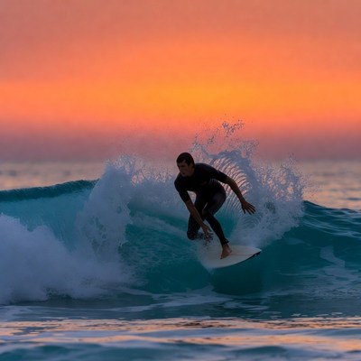 Man surfing wave at sunset