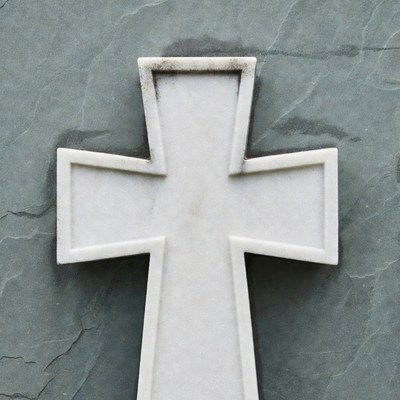 White stone cross on gray slate