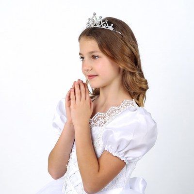 Girl praying with crown and white dress