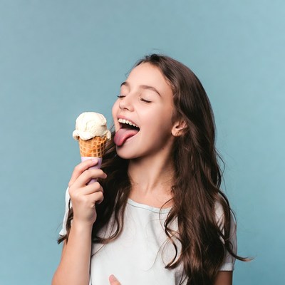 Girl licking vanilla ice cream cone