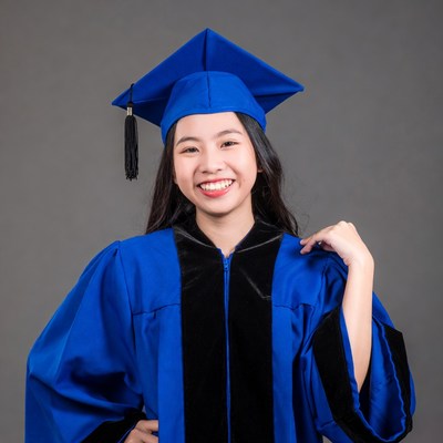 Asian woman in blue graduation gown