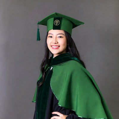 Asian woman in green graduation gown