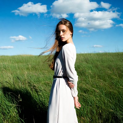 Woman in white dress in green field