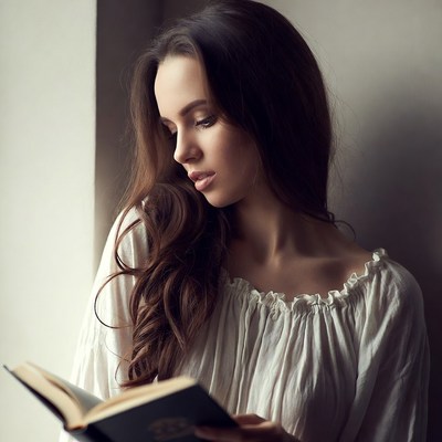 Woman reading book by window