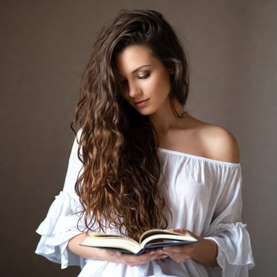Woman reading book with curly hair