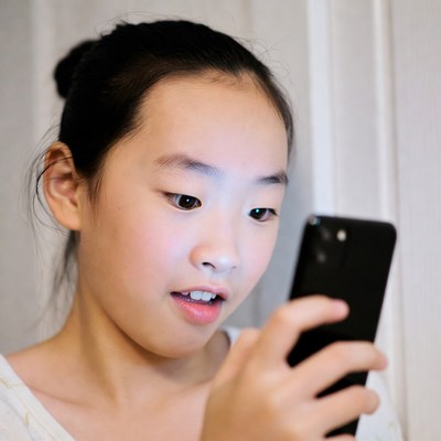 Asian girl surprised using smartphone