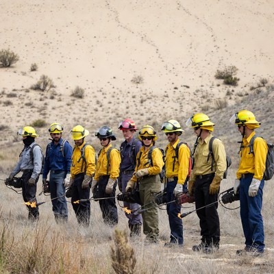 Firefighters standing in desert with tools
